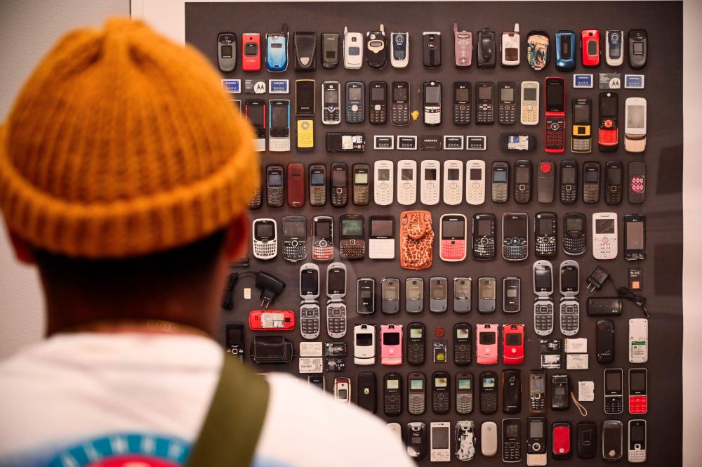 A visitor looks at a photo of cell phones confiscated from migrants at the exhibition Sueno Americano / The American Dream: Photographs by Tom Kiefer at the Skirball Cultural Center in Los Angeles, on Dec 10. — AFP