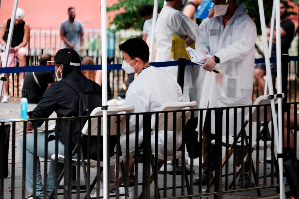 NEW YORK, NEW YORK - JULY 29: Healthcare workers with New York City Department of Health and Mental Hygiene work at intake tents where individuals are registered to receive the monkeypox vaccine on July 29, 2022 in New York City. AFPPIX