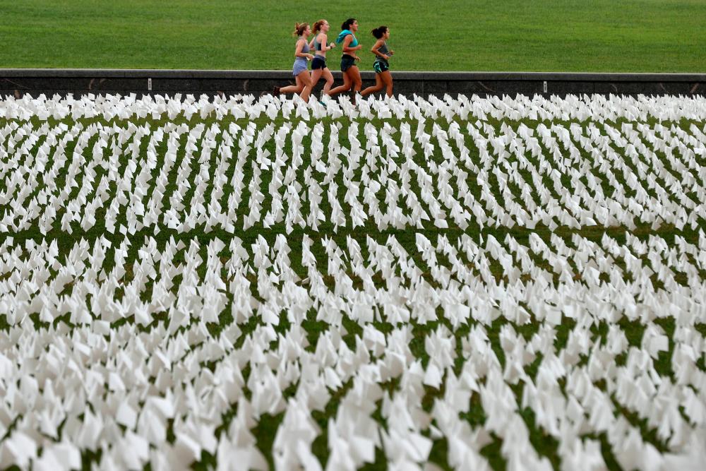 Runners pass ‘In America: Remember,‘ a public art installation commemorating all the Americans who have died due to Covid-19 near the Washington Monument on September 17, 2021 in Washington, DC.- AFPpix