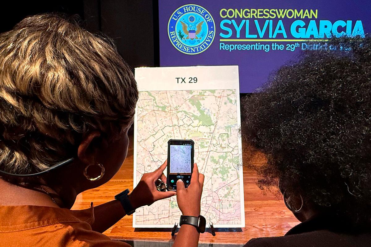 Voters look at a map to understand the new redistricting maps approved by Texas lawmakers for the 2026 midterm elections, at San Jacinto College in Houston, Texas, on August 27, 2025. - MOISES AVILA / AFP