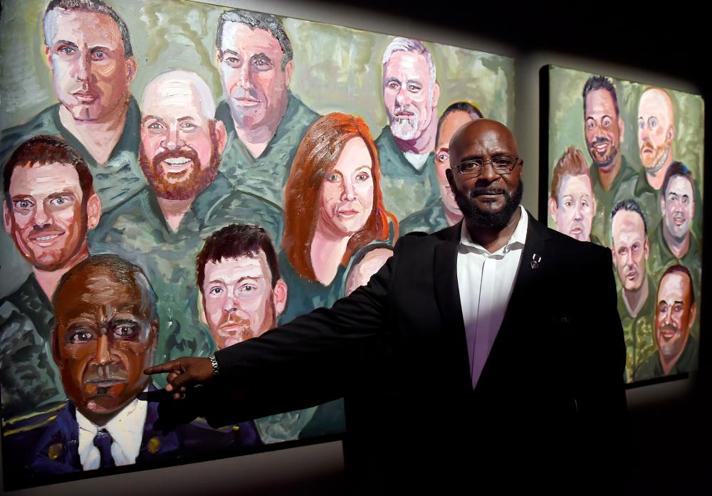 US Army Sergeant DeWitt Osborne poses next to his painting made by former US President George W. Bush at the Portraits of Courage exhibit at the Kennedy Center in Washington, DC on Oct 7, 2019. — AFP