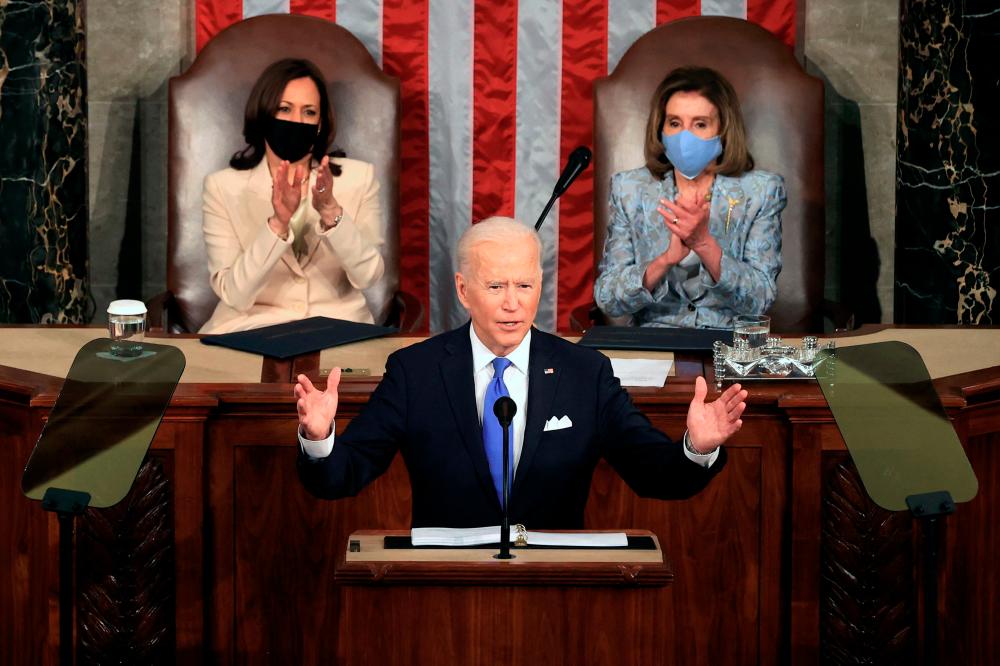 US President Joe Biden, flanked by US Vice President Kamala Harris (L) and Speaker of the House of Representatives Nancy Pelosi (R), addresses a joint session of Congress at the US Capitol in Washington, DC, on April 28, 2021. -AFP