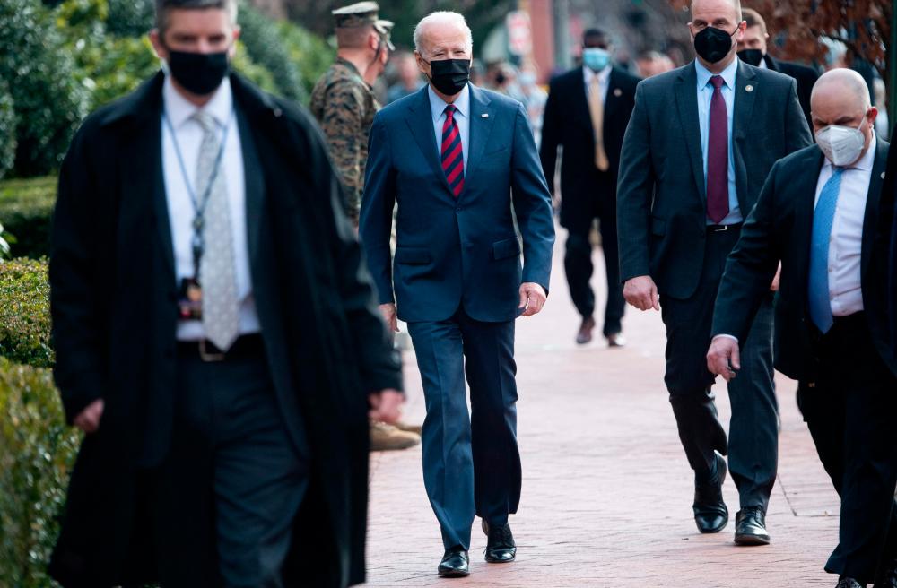 US President Joe Biden, surrounded by members of the US Secret Service, makes a surprise walk down Barracks Row in Washington, DC, on January 25, 2022. AFPPIX