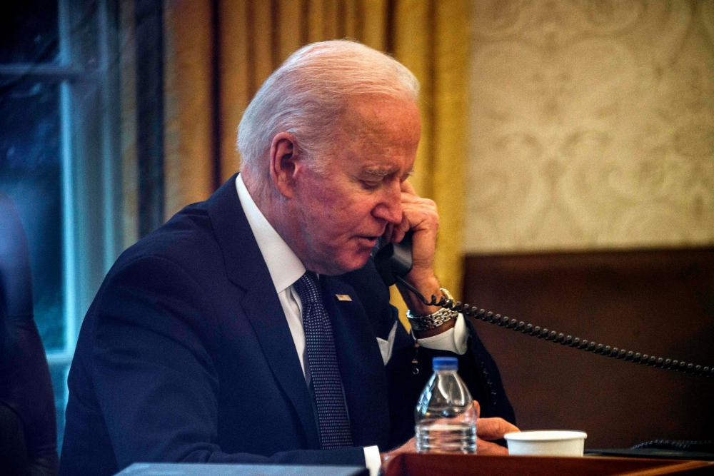 US President Joe Biden speaks on the phone to his Ukrainian counterpart Volodymyr Zelensky in the Oval Office at the White House in Washington, DC, on December 9, 2021. AFPpix