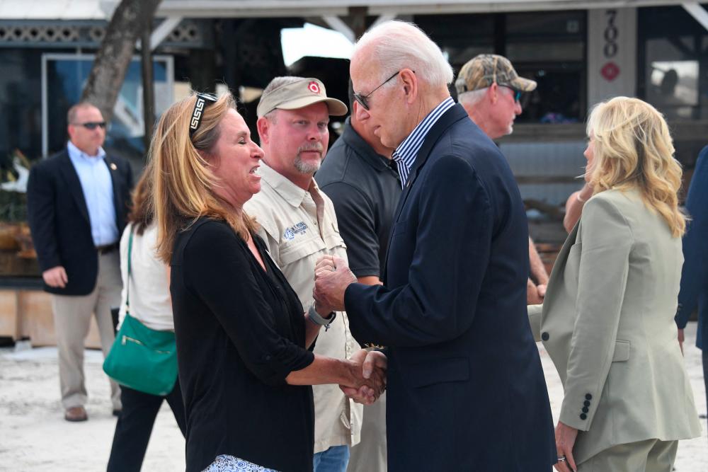 US President Joe Biden and US First Lady Jill Biden speak with local residents impacted by Hurricane Ian at Fisherman’s Pass in Fort Myers, Florida, on October 5, 2022. AFPPIX