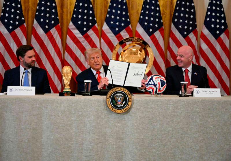 US President Donald Trump holds up a document creating the “White House Task Force on the FIFA World Cup 2026” as US Vice President JD Vance (L) and FIFA president (Fédération Internationale de Football Association) Gianni Infantino look on in the East Room of the White house in Washington, DC, on May 6, 2025. AFPpix