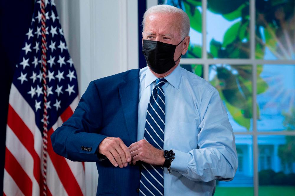 US President Joe Biden puts on his suit jacket after receiving a third shot of the Pfizer Covid-19 vaccine as a booster on the White House campus September 27, 2021, in Washington, DC. AFPpix