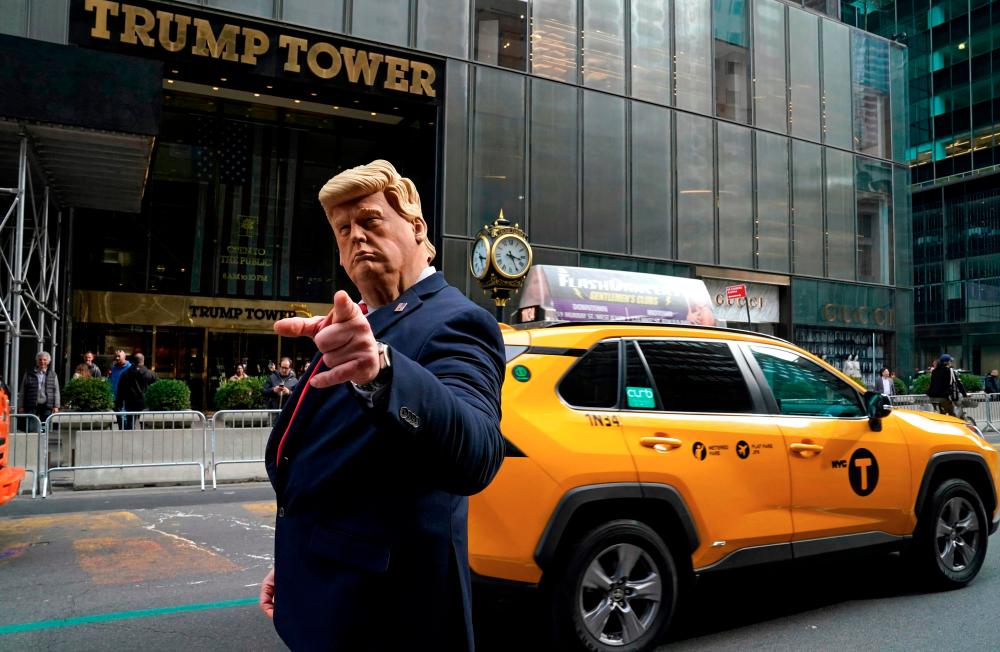 Former US President Donald Trump's impersonator Neil Greenfield gestures outside Trump Tower in New York City on March 22, 2023. AFPPIX