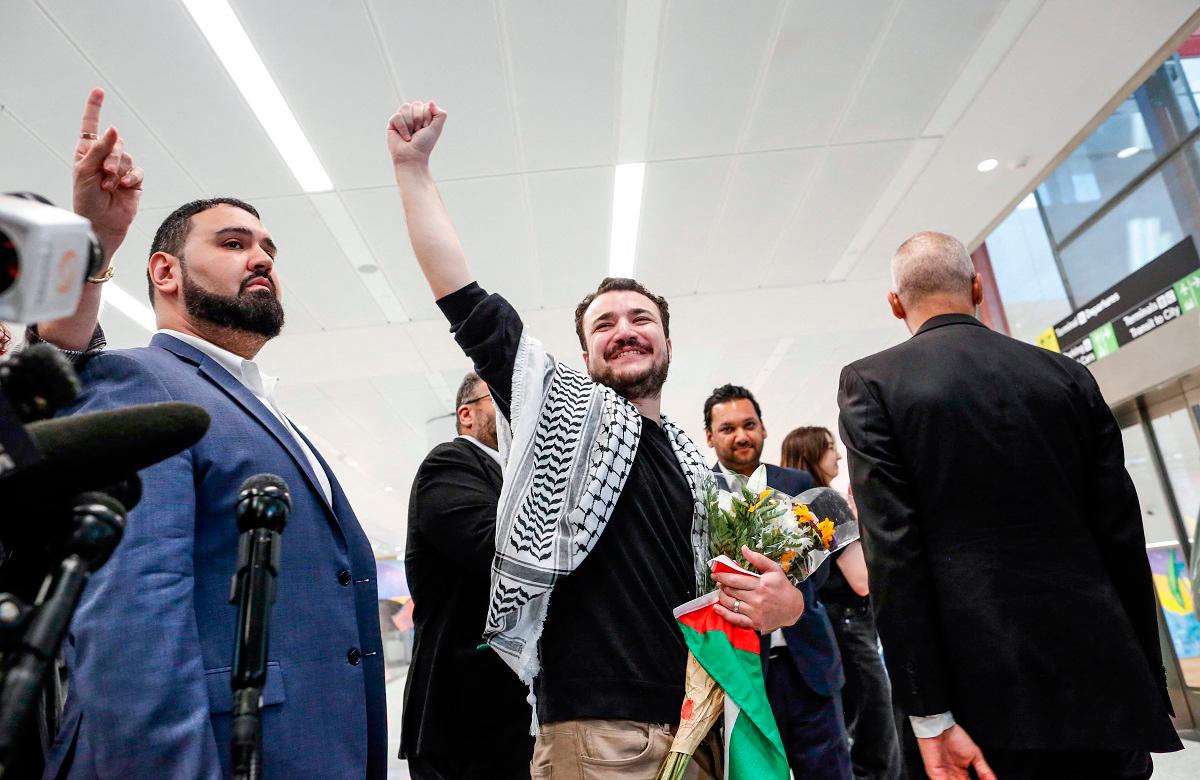Former Columbia Univrsity student Mahmoud Khalil raises his fist after speaking to the press as he arrives at Newark airport in Newark, New Jersey, on June 21, 2025. - kena betancur / AFP