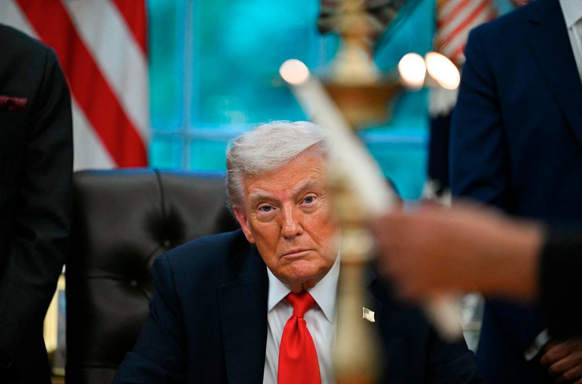 US President Donald Trump looks on as candles are lit during a Diwali celebration with American Indian leaders in the Oval Office of the White House in Washington, DC, on October 21, 2025. - AFP