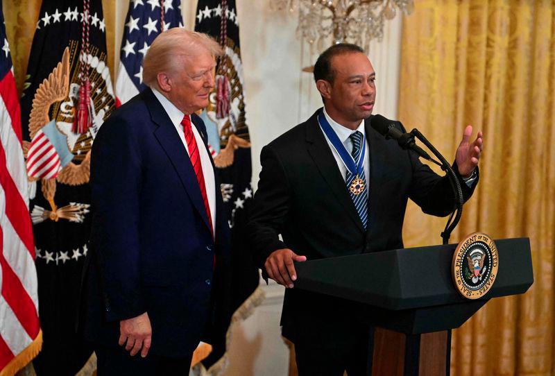 US golfing legend Tiger Woods speaks as President Donald Trump looks on during a reception for Black History Month in the East Room of the White House on February 20, 2025 in Washington, DC. - AFPPIX