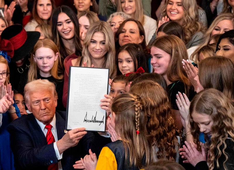 US President Donald Trump holds up the No Men in Women’s Sports Executive Order after signing it in the East Room of the White House - AFPpix