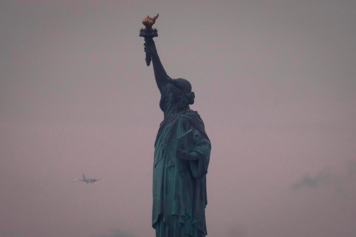 A plane prepares to land at Newark Liberty International Airport behind the Statue of Liberty on June 8, 2025 in New York City. AFPpix