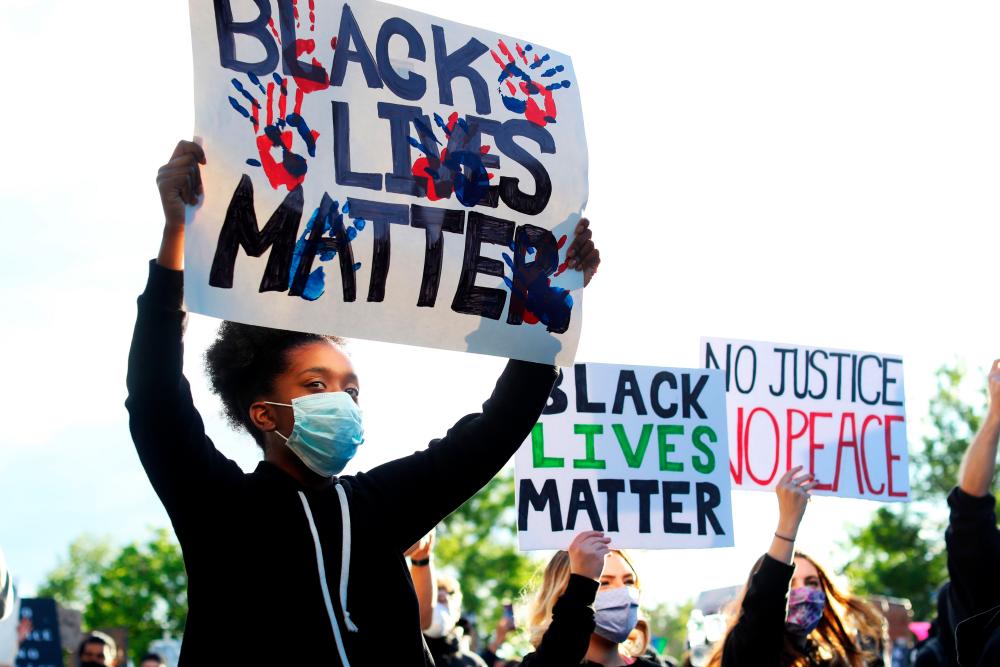 Demonstrators protest in response to the recent death of George Floyd on May 30, 2020 in Boston, Massachusetts. Protests spread across cities in the US, and in other parts of the world in response to the death of African American George Floyd while in police custody in Minneapolis, Minnesota. - AFP