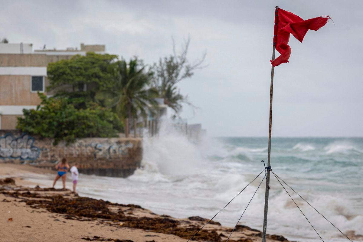 A ripped red flag warning of rip current waves as Category 5 Hurricane Erin approaches in San Juan, Puerto Rico, on August 16, 2025. Hurricane Erin on Saturday strengthened to a “catastrophic” Category 5 storm as it barrelled towards the Caribbean, with weather officials warning of possible flash floods and landslides. (Photo by Ricardo ARDUENGO / AFP)