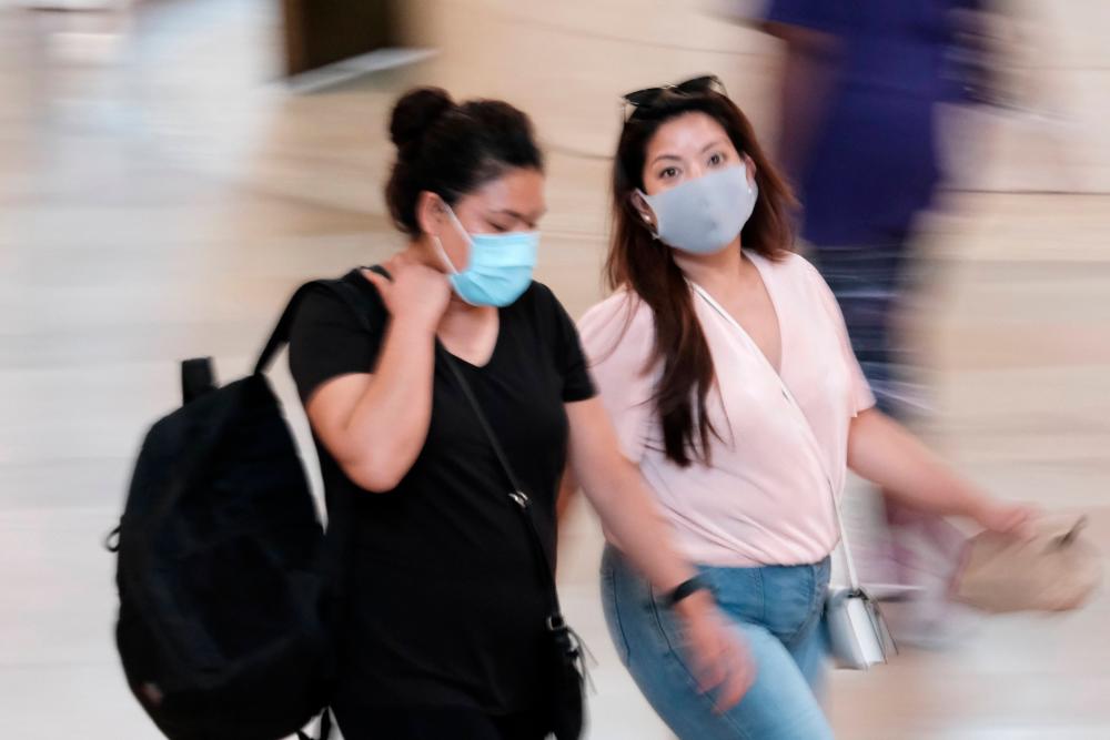 People wear masks while walking in Grand Central Terminal on July 27, 2021 in New York City. -AFP