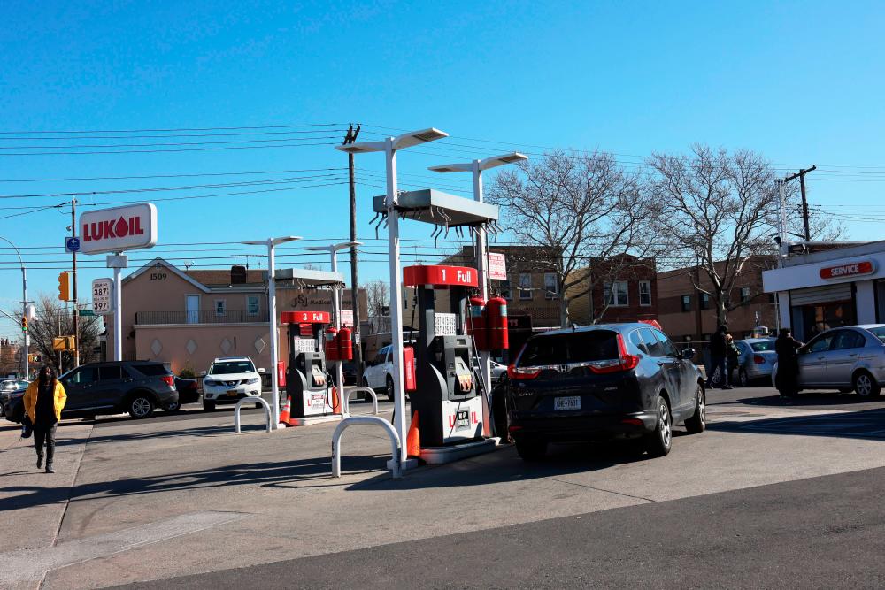 People walk past a Lukoil gas station is seen on March 04, 2022 in the Canarsie neighborhood of Brooklyn in New York City. - AFPpix