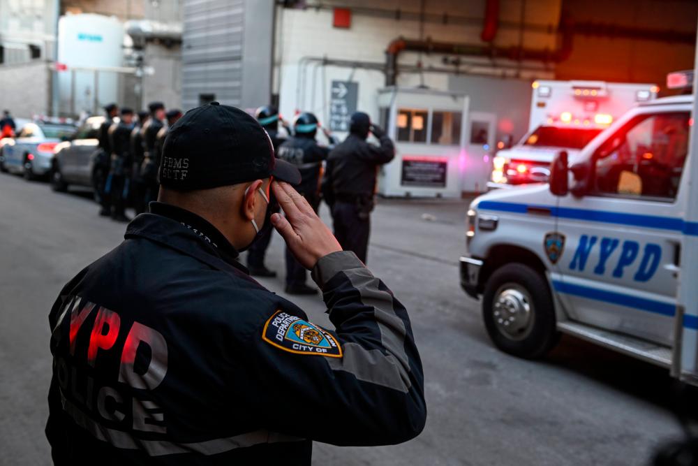 NEW YORK, NEW YORK - JANUARY 25: NYPD officers line up and salute as the body of Officer Wilbert Mora is transferred in an ambulance from NYU Langone Hospital to a Medical Examiner’s office at the same location on January 25, 2022 in New York City. AFPPIX
