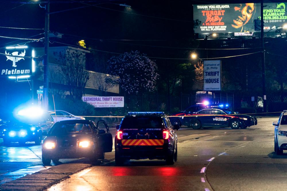Atlanta Police vehicules are seen outside a massage parlor where a person was shot and killed on March 16, 2021, in Atlanta, Georgia. Eight people were killed in shootings at three different spas in the US state of Georgia on March 16 and a 21-year-old male suspect was in custody, police and local media reported, though it was unclear if the attacks were related. - AFP