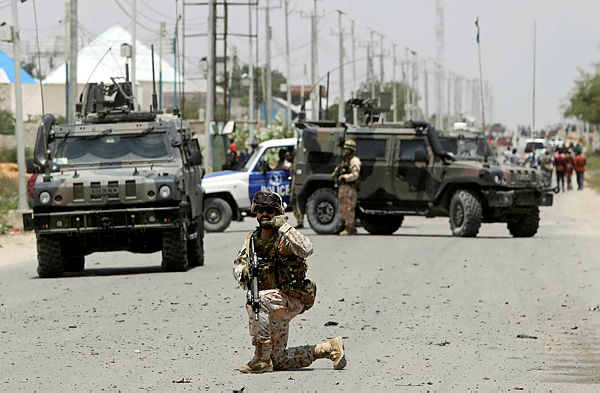 A soldier holds a position as damage is assessed after Islamist group al Shabaab hit a European Union armoured convoy in Mogadishu, Somalia — Reuters
