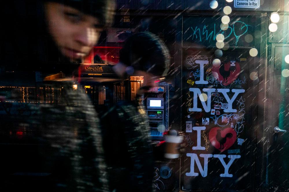 People walk through lower Manhattan as it snows on January 06, 2024 in New York City/AFPPix