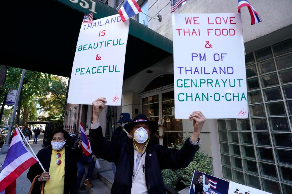 Protestors hold up signs outside the Royal Thai Consulate General New York Sept 19, 2020, as part of a worldwide protest demanding new elections and reforms in the monarchy. — AFP