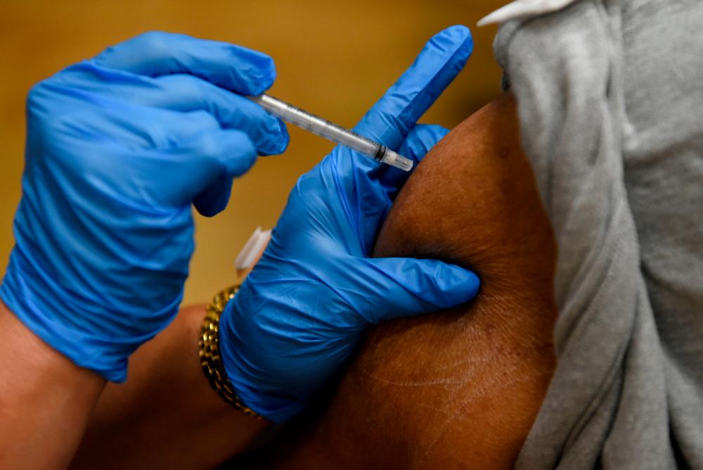 FILE PHOTO: A person receives a vaccine for the coronavirus disease (Covid-19) at Acres Home Multi-Service Center in Houston, Texas, U.S., October 13, 2021. REUTERSpix