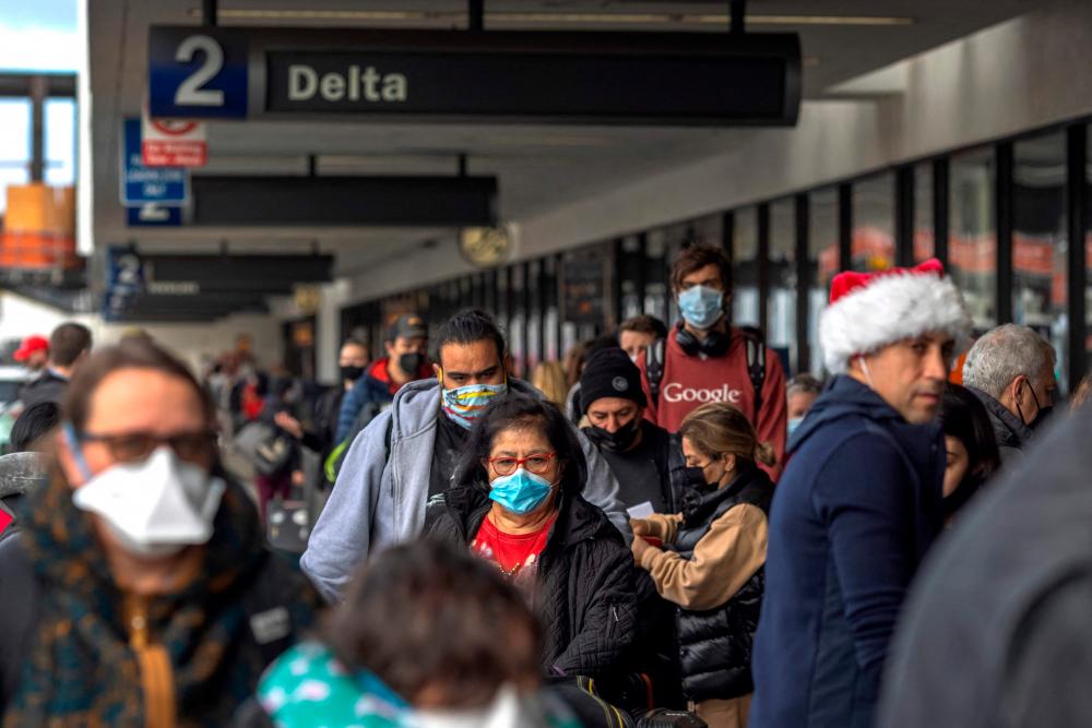 Travelers arrive at Los Angeles International Airport in Los Angeles, California, on December 23, 2021. AFPPIX