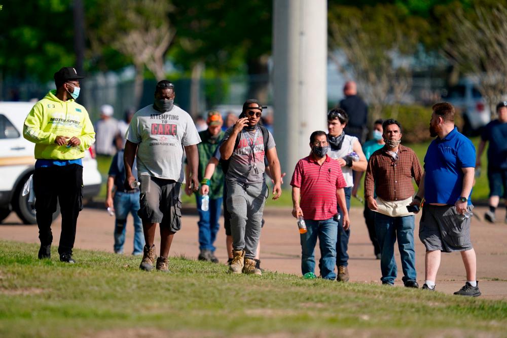 Workers of surrounding businesses are let go by police after a mass shooting at an industrial park in Bryan, Texas on April 8, 2021. Several victims were rushed to hospital after being shot at a business in Texas, just hours after US President Joe Biden called gun violence an epidemic and unveiled plans to tackle the crisis. –AFP