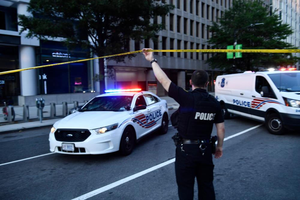 Police activity at the entrance to Pennsylvania Avenue near the White House shortly after Secret Service guards shot a person who was apparently armed, outside the White House on August 10, 2020 while US President Donald Trump was speaking to the press in the Brady Briefing Room of the White House in Washington, DC. — AFP