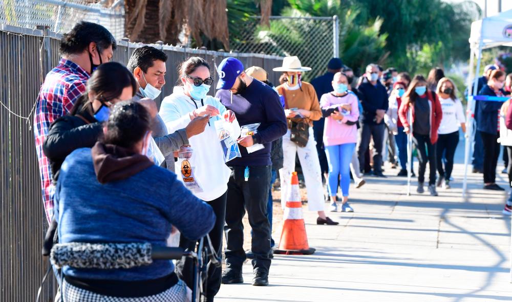 People line up for their Covid-19 test at a mobile pop-up test site in Los Angeles, California on December 3, 2020, where Health officials are warning that the surge in Covid-19 cases ravaging Los Angeles County could threaten the availability of intensive-care beds by Christmas. — AFP