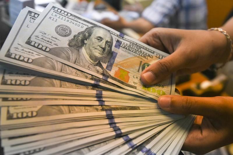 An employee shows U.S. dollars banknotes at a money changer in Jakarta, Indonesia, April 24, 2018. Antara Foto/Hafidz Mubarak/via REUTERS