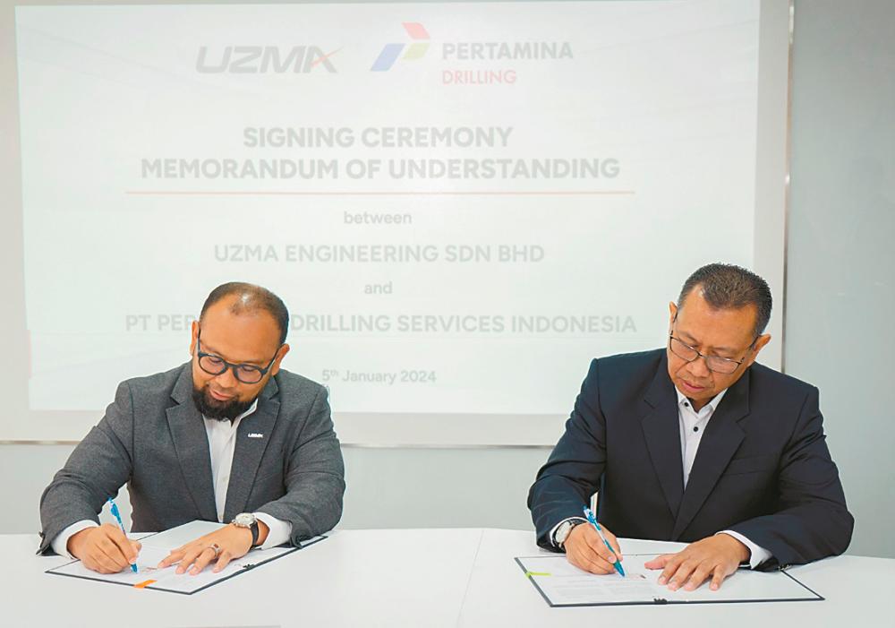 Kamarul Redzuan (left) and Rio during the signing ceremony.