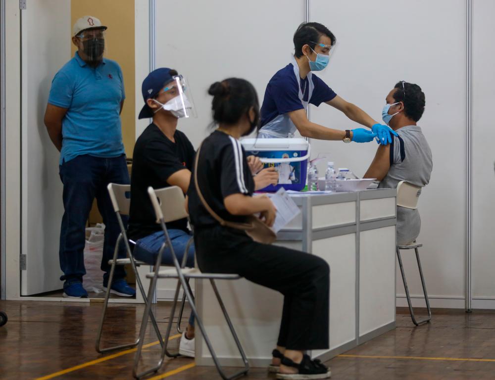 People receive a dose of the Covid-19 vaccine during Selangor Vaccination Programme (Selvax) at Dewan Seberguna Taman Eng Ann Klang. — Asyraf Rasid /THESUN