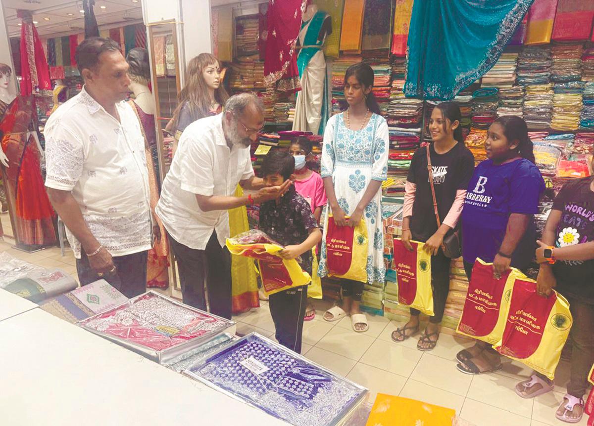 Rajendran presenting the gifts to the children during the event. – P. CHANDRA SAGARAN/THESUN