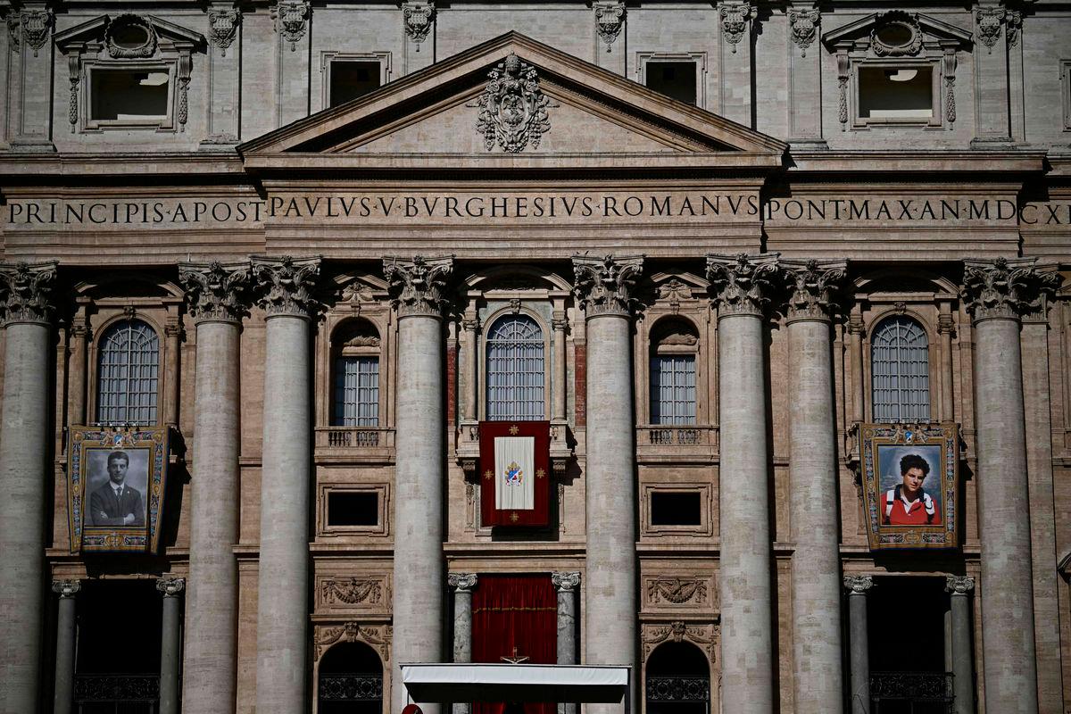Portraits of late Pier Giorgio Frassati (L) and late Italian teenager Carlo Acutis are displayed onto the facade of Saint Peter’s Basilica ahead of a Holy Mass and canonisation of Blessed Carlo Acutis and Pier Giorgio Frassati in St Peter’s Square at the Vatican on September 7, 2025.