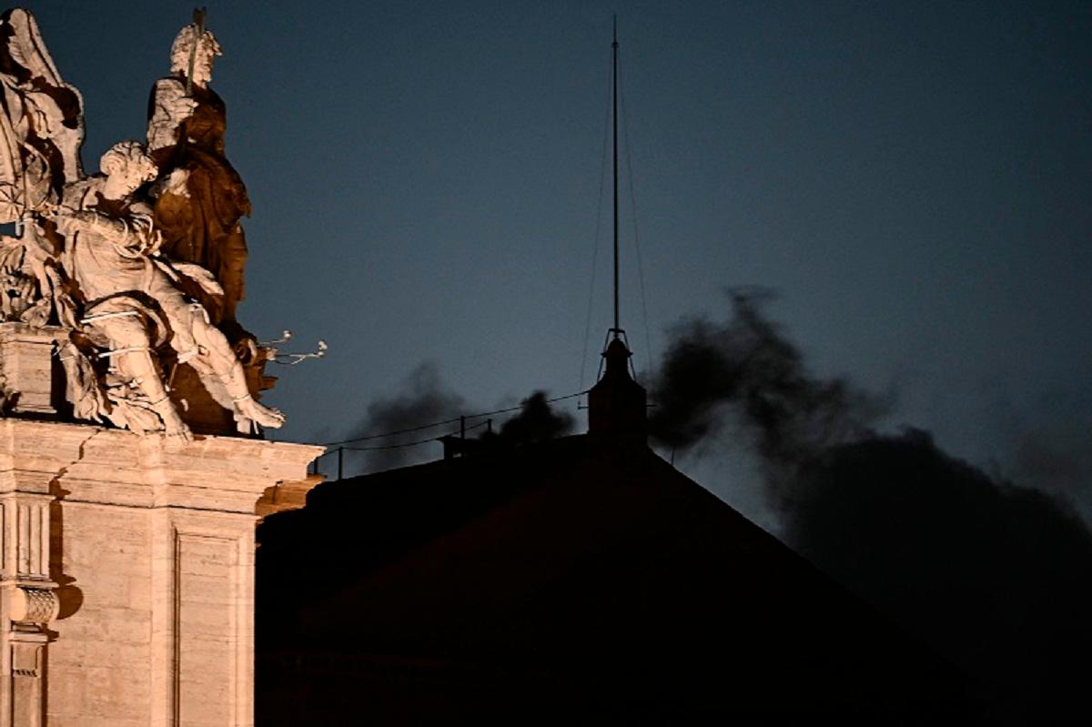 This photograph shows black smoke rising from the chimney of the Sistine Chapel signalling that cardinals failed to elect a new pope in the first ballot of their conclave in the Vatican on May 7, 2025. - Filippo MONTEFORTE / AFP