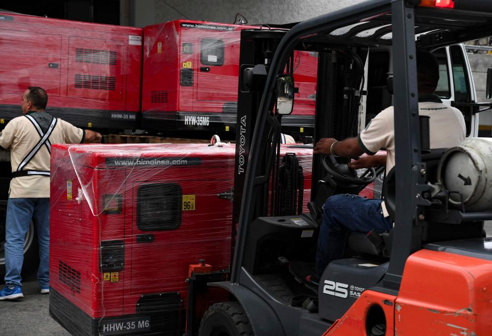 A worker unloads generators received as part of humanitarian aid through the Venezuelan Red Cross in Caracas, Venezuela on June 17, 2019. — AFP