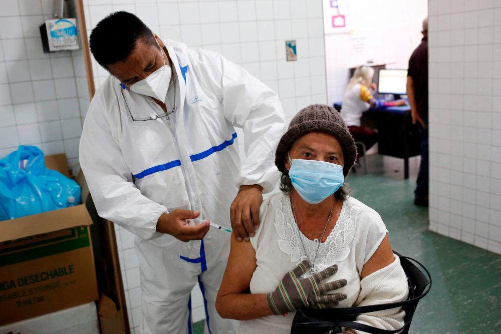 A health worker administers a dose of the Sputnik V vaccine against COVID-19 to an eldery woman at the Victorino Santaella Hospital in Los Teques, Venezuela on April 9, 2021, amid the ongoing coronavirus pandemic. -AFP