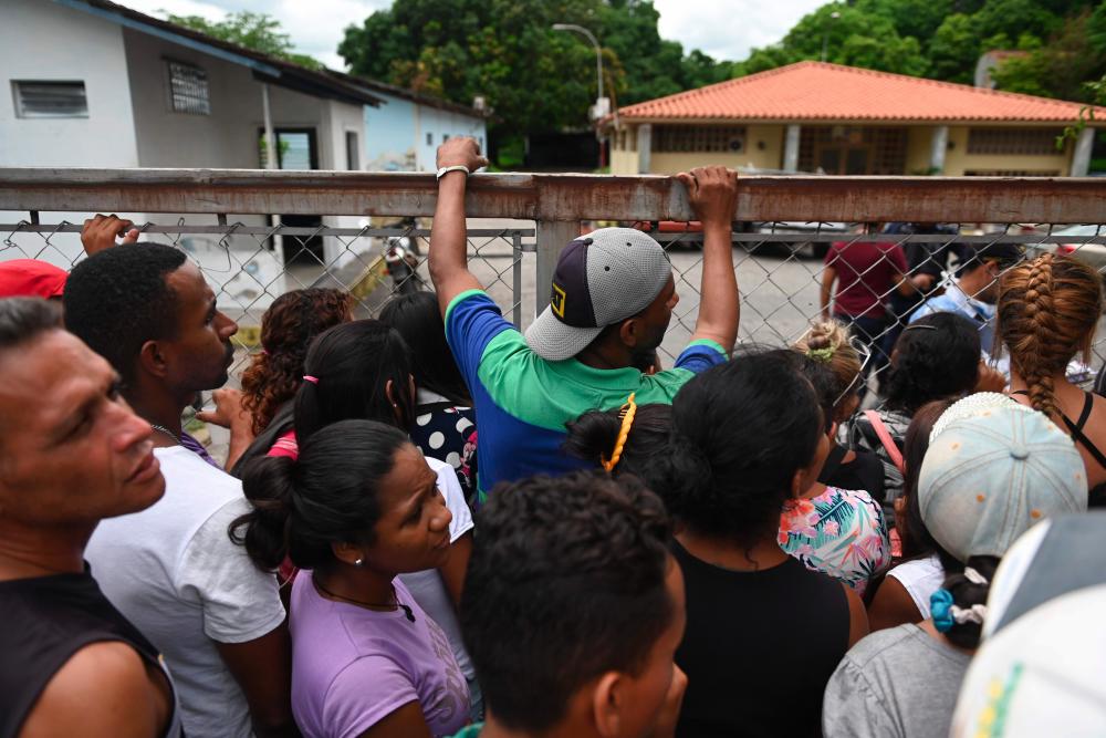 Relatives of prisoners killed on the eve during clashes at a police station jail in the town of Acarigua, in the Venezuelan state of Portuguesa, wait outside a hospital's morgue to be handed the bodies of their loved ones, on May 25, 2019. - AFP