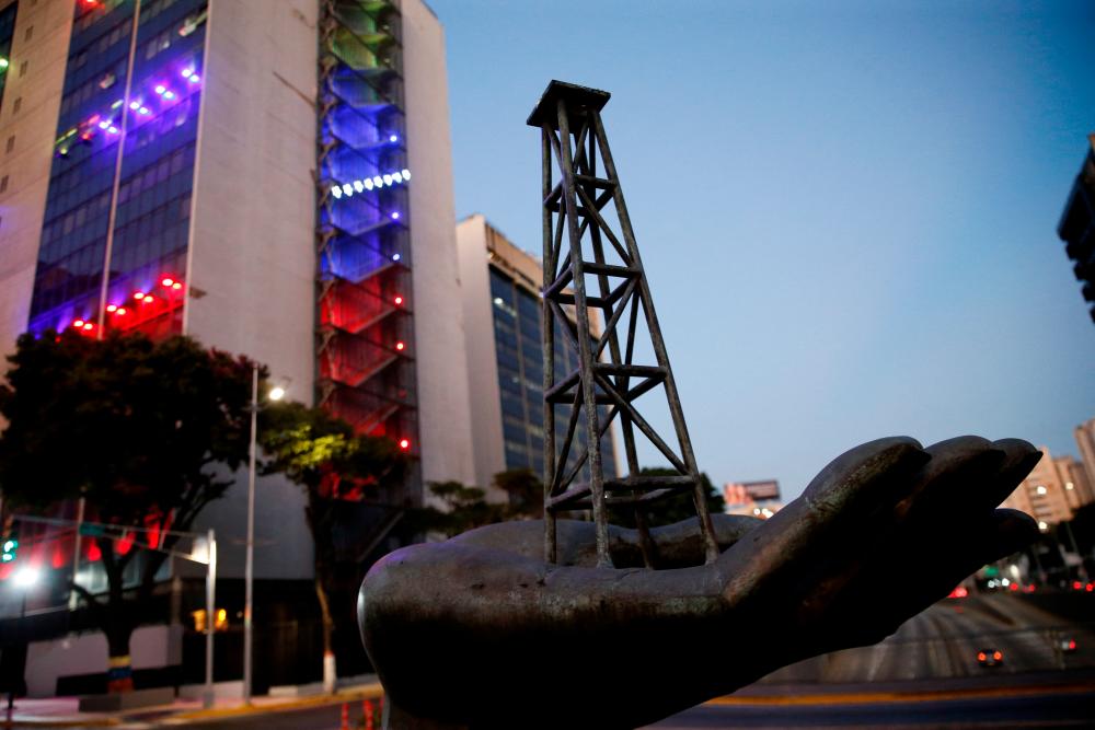 A sculpture depicting an oil tower on a hand of Venezuela’s state oil company PDVSA is pictured near the company’s headquarters, in Caracas on March 20, 2023. – Reuterspic