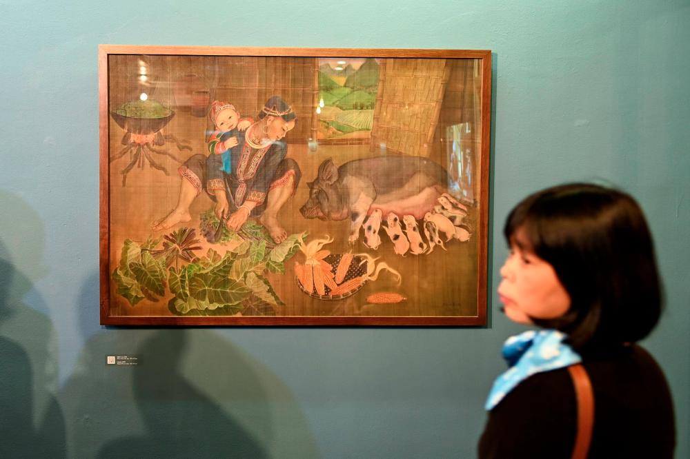 $!This photograph taken on October 22, 2020 shows a visitor looking at a painting by 89-year-old Vietnamese artist Mong Bich during the opening of her first solo exhibition at the French Cultural Centre in Hanoi. AFP / Manan VATSYAYANA