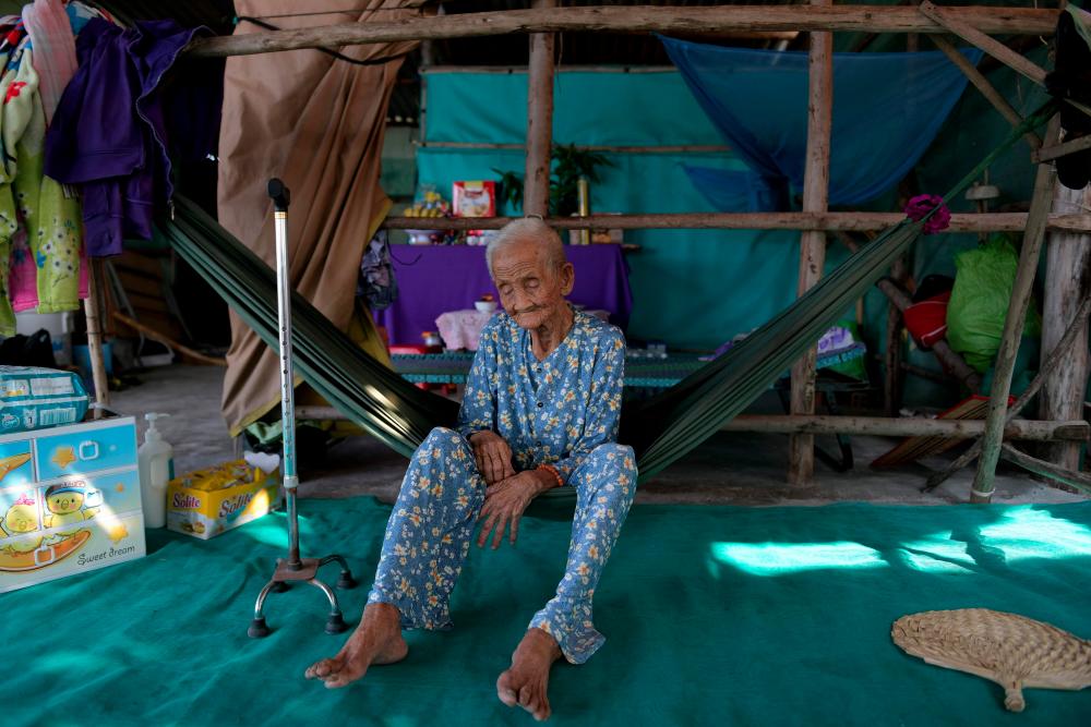 This photograph taken on April 21, 2019 shows 99-year-old Pham Thi Ca resting in a hammock in her makeshift shelter in Van Phong Bay. — AFP
