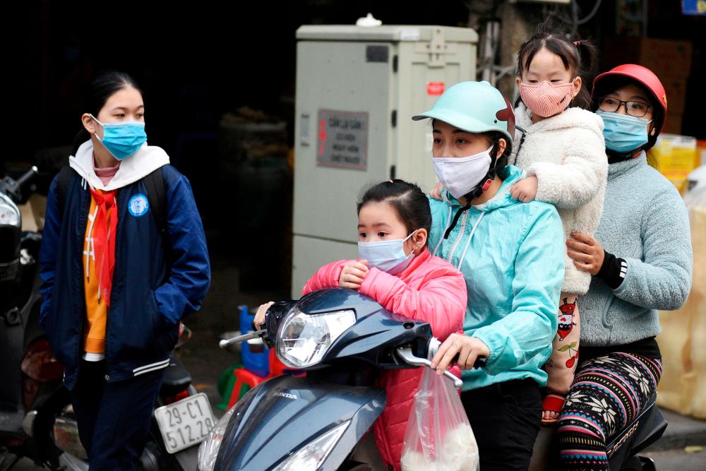 FILE PHOTO: A family wears protective masks as they ride a motorbike in the street amid the coronavirus disease (Covid-19) outbreak in Hanoi, Vietnam, January 29, 2021. — Reuters