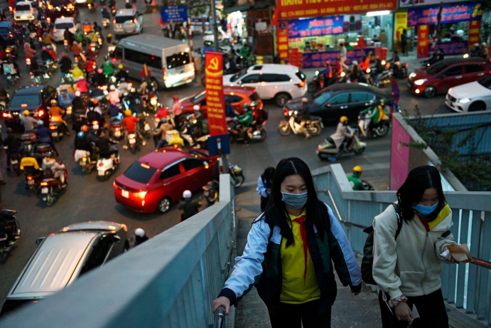 Girls walk in a overpass as they wear protective masks in the street amid the coronavirus disease (Covid-19) outbreak in Hanoi, Vietnam, January 29, 2021. — Reuters
