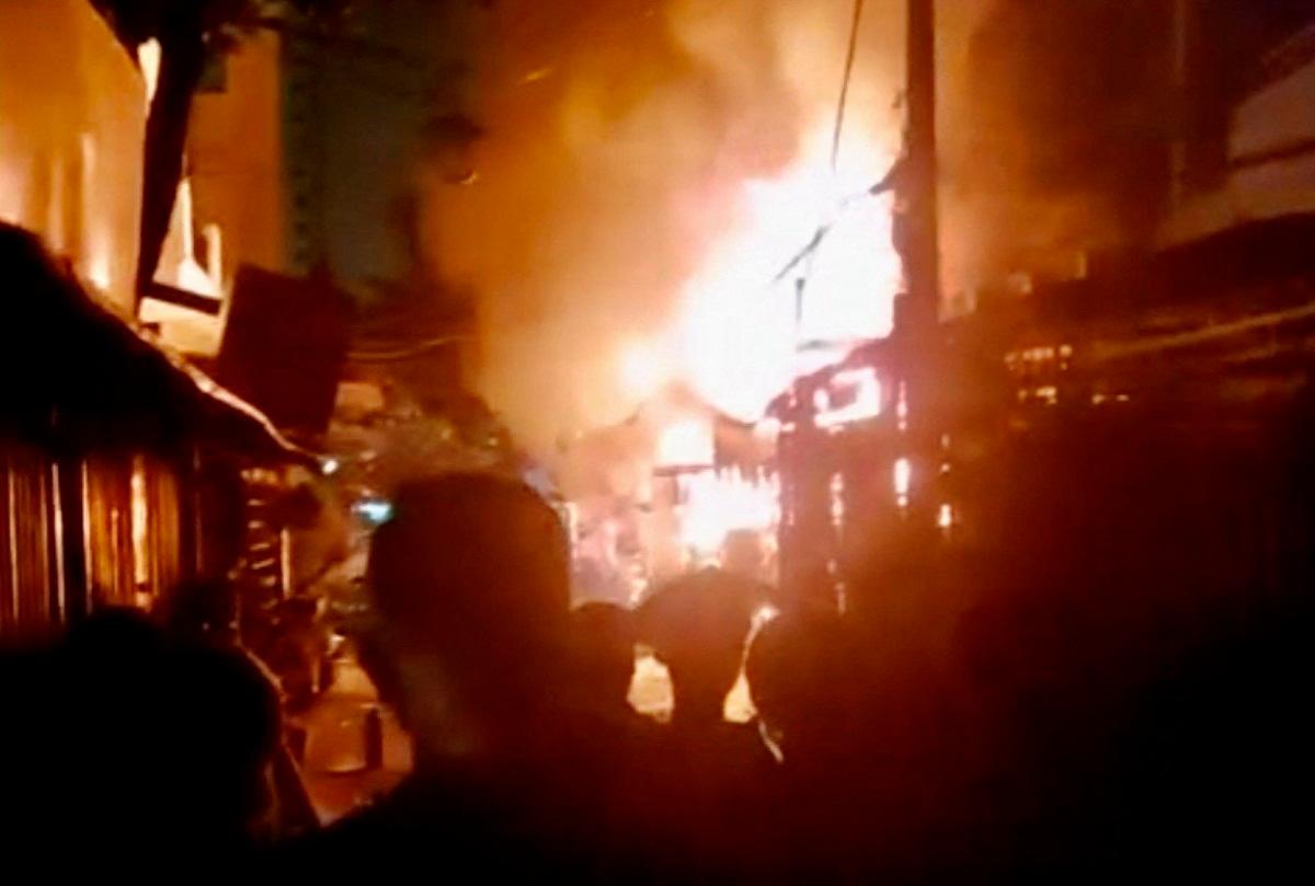 This photo released by the Vietnam News Agency (VNA) on July 7, 2025 shows people watching a fire at an apartment block in Ho Chi Minh City on July 6, 2025. A blaze that tore through an apartment block in Vietnam's southern business hub of Ho Chi Minh City killed eight people, including two children, local authorities said on July 7. - Vietnam News Agency / VIETNAM NEWS AGENCY / AFP