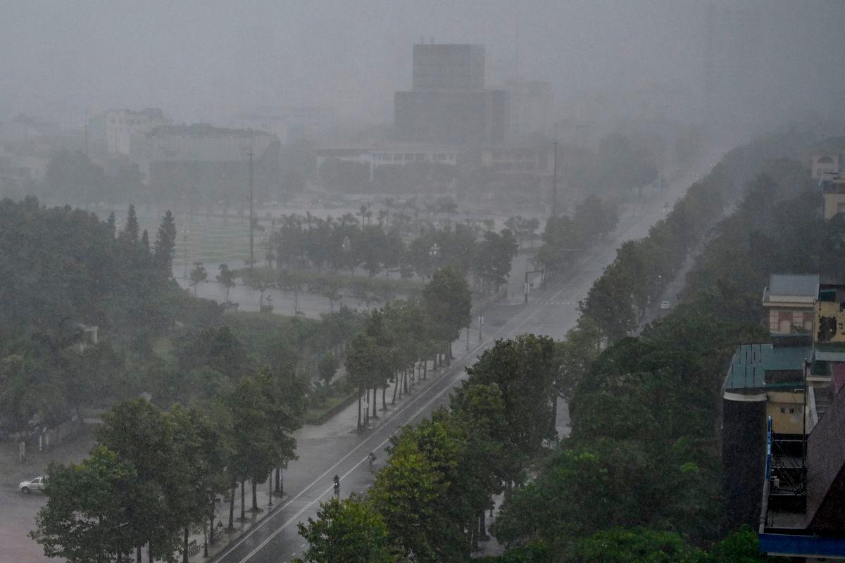 Rain falls above the buildings and a street in Vinh city, Nghe An province on August 25, 2025, before Typhoon Kajiki makes landfall in Vietnam. Tens of thousands of residents were being evacuated from coastal Vietnam on August 25, as Typhoon Kajiki barrelled towards landfall expected to lash the country’s central belt with gales of around 160 kmh. The typhoon -- the fifth to affect Vietnam this year -- is currently at sea, roiling the Gulf of Tonkin with waves of up to 9.5 metres (31 feet). (Photo by Nhac NGUYEN / AFP)