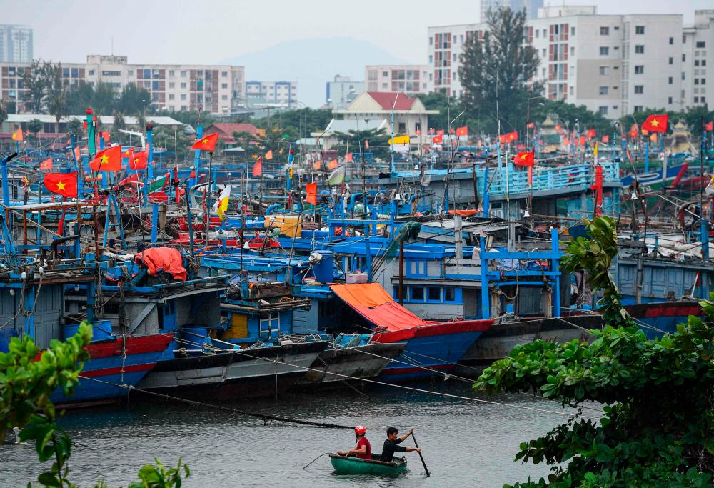 Fishermen sail a boat on the Han river in Danang on September 27, 2022. Vietnam has tried to evacuate almost 400,000 people as typhoon Noru, one of the biggest to make landfall in the country, draws near, authorities said on September 27, 2022/AFPPix