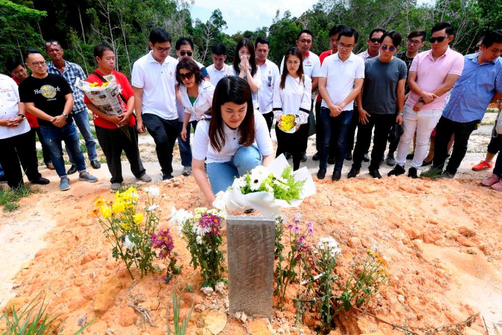 Wong placing flowers on her father’s grave at the Sandakan Christian Cemetery yesterday. — Bernama