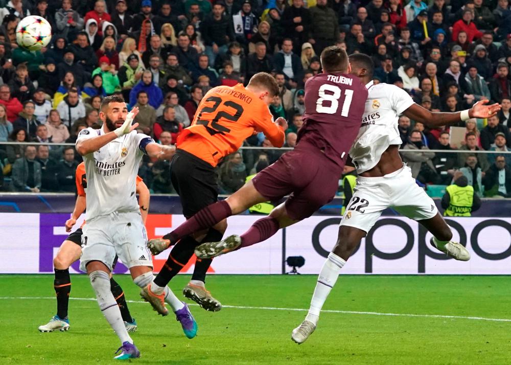Antonio Rudiger leapt to reach a long ball forward and got to it just before goalie Anatoliy Trubin/AFPPIX